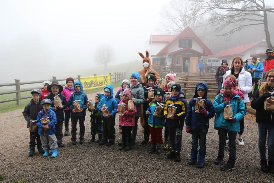 Gruppenfoto mit dem Osterhasen und den Kindern, die bei regen und Graupelschauer den Berg erklommen.